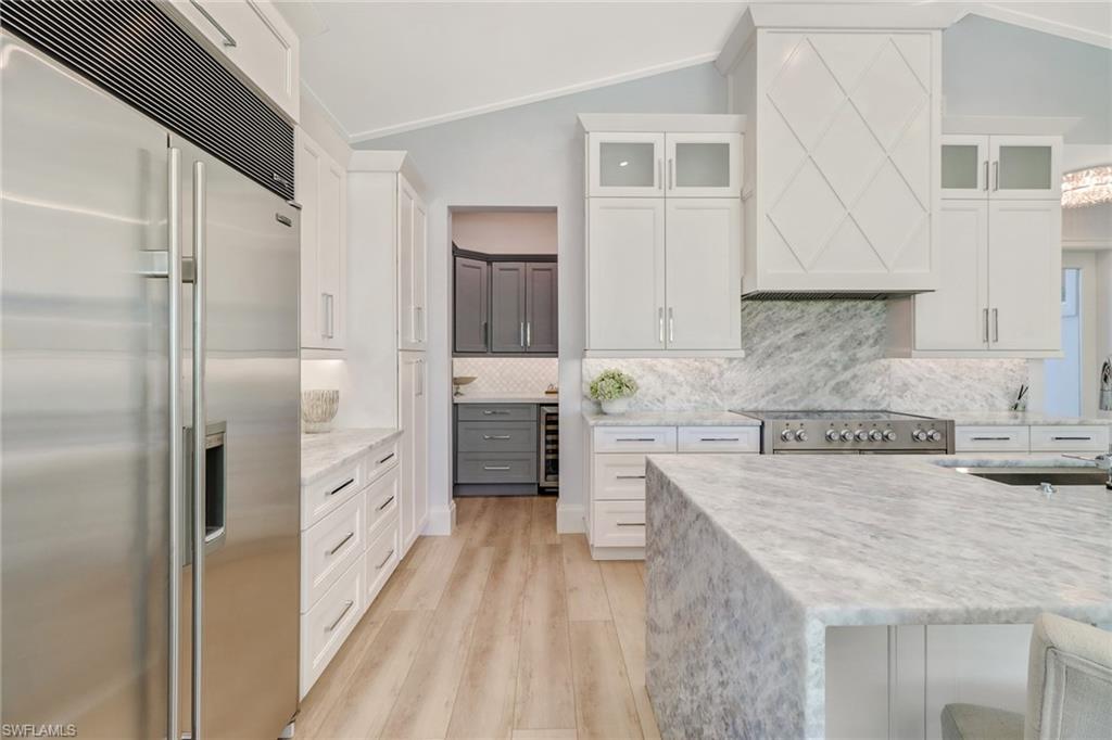 5130 Alpha Court Naples, FL 34105 - Photo 5 of 35 a kitchen with stainless steel appliances granite countertop a refrigerator a stove and white cabinets