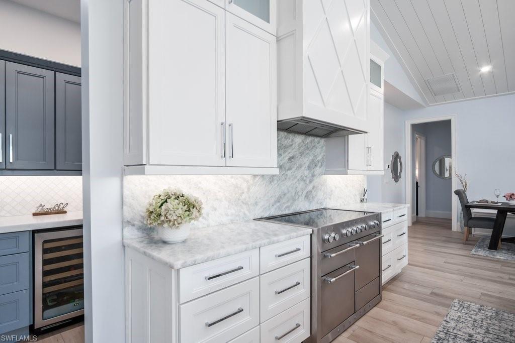 5130 Alpha Court Naples, FL 34105 - Photo 6 of 35 a kitchen with stainless steel appliances granite countertop a sink stove and cabinets