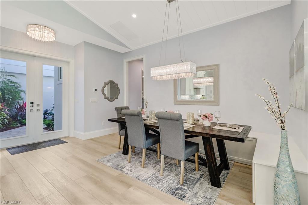 5130 Alpha Court Naples, FL 34105 - Photo 7 of 35 a view of a dining room with furniture and wooden floor