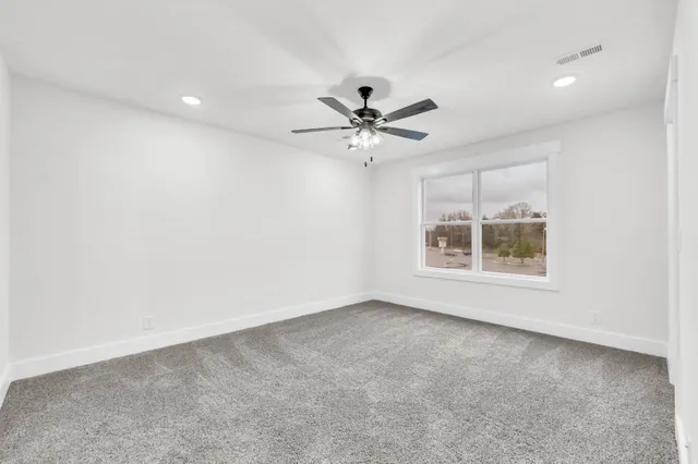 an empty room with a empty space and a ceiling fan