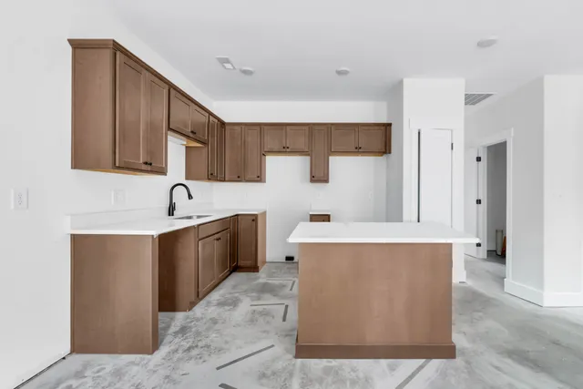 a kitchen with stainless steel appliances a sink a stove top oven a refrigerator and dishwasher