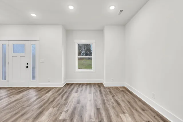 wooden floor in an empty room with a window