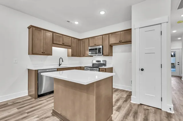 a kitchen with a sink a stove a refrigerator a center island and a window