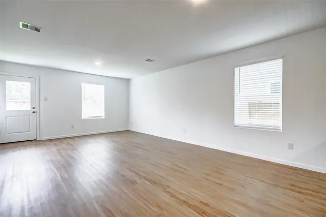 a view of a kitchen with wooden floor and a window