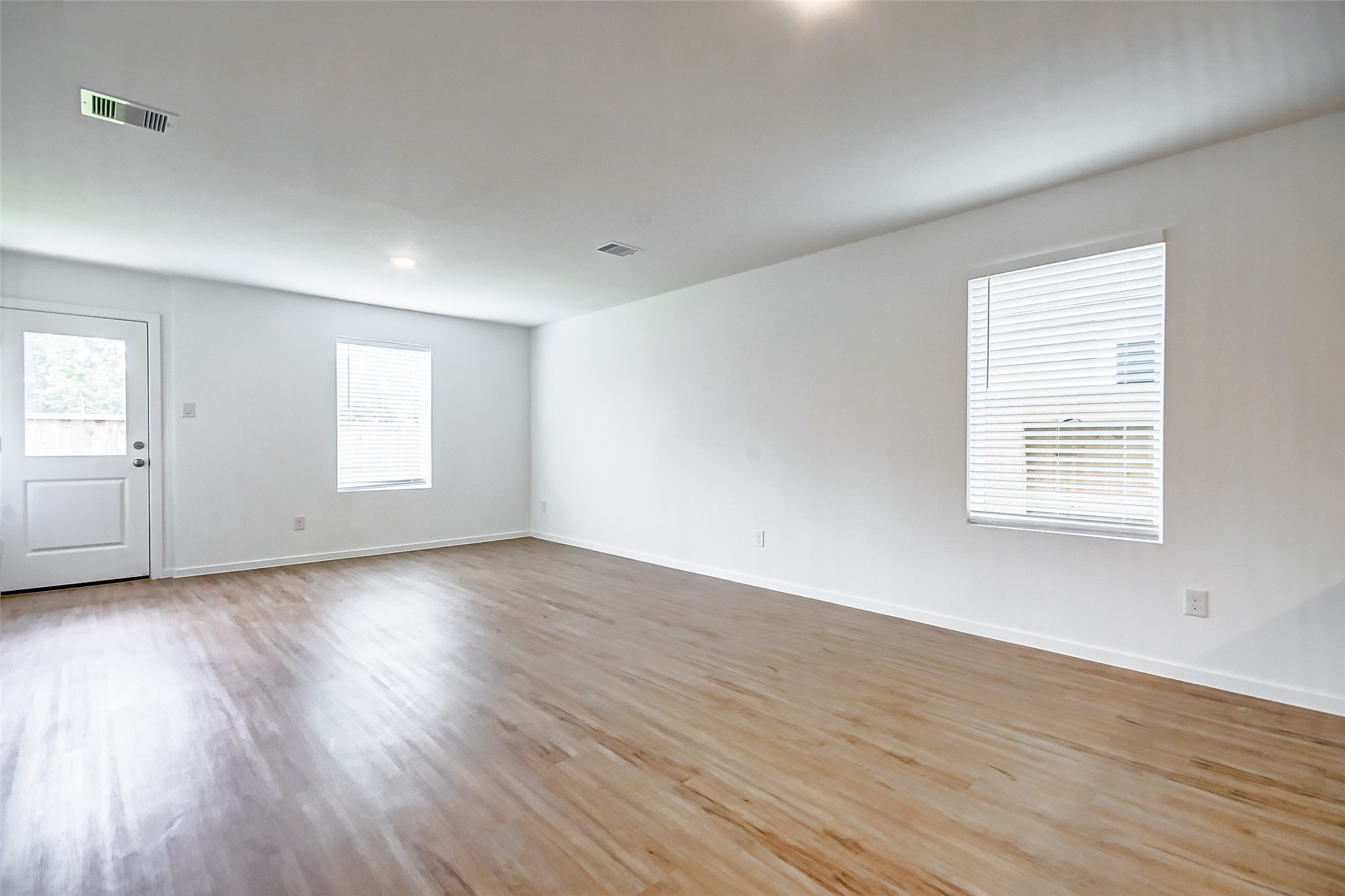 21535 Carosella Drive New Caney, TX 77357 - Photo 11 of 25 an empty room with wooden floor and windows
