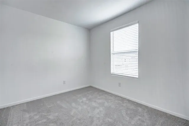 an empty room with white wall and shower