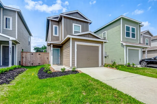 a front view of a house with a yard and garage