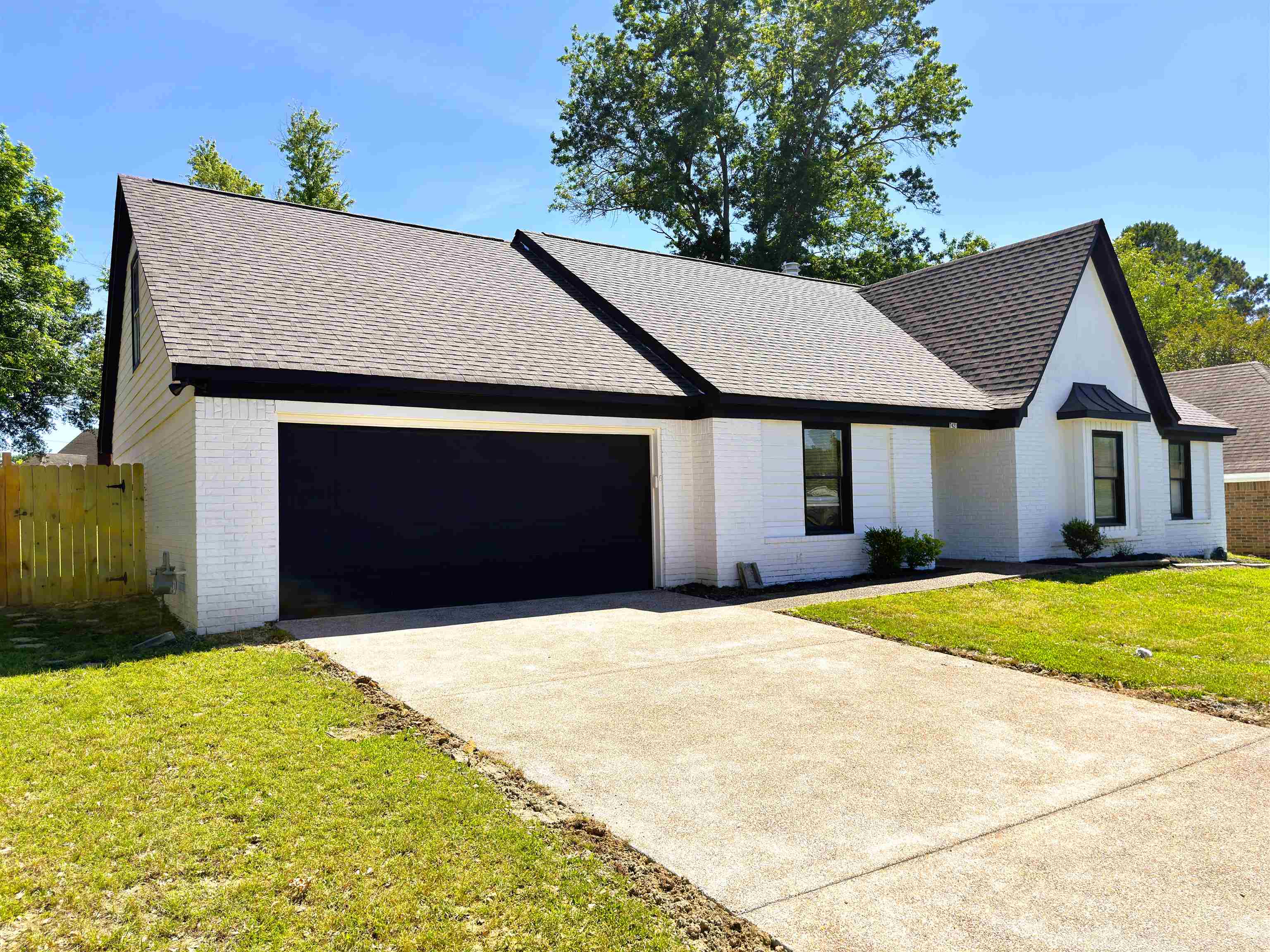 7421 Richmond Road Memphis, TN 38125 - Photo 4 of 39 White brick exterior with black trim, featuring a dark asphalt shingle roof