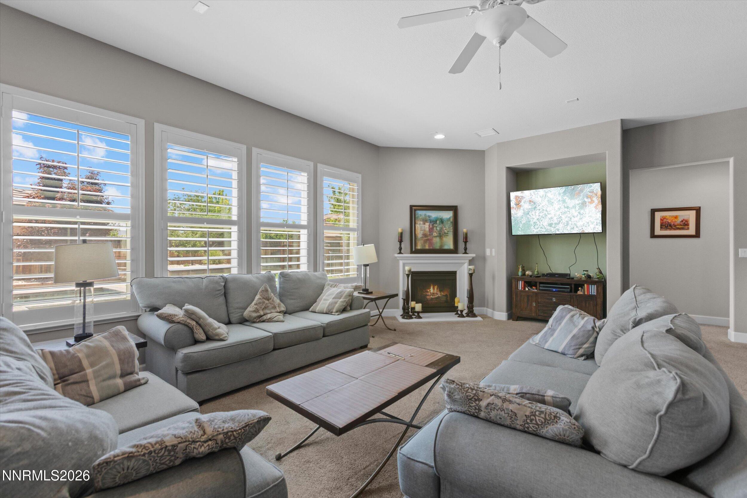 2920 Bull Rider Drive Reno, NV 89521 - Photo 16 of 51 a living room with furniture a large window and a fireplace