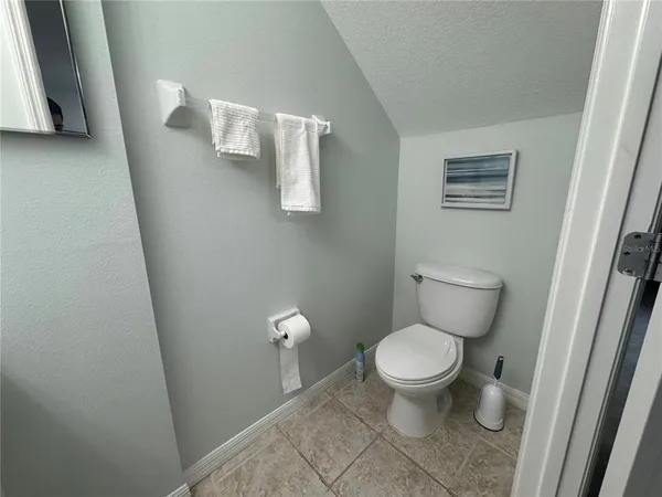 a white toilet sitting next to a white cabinet