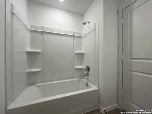 a white bath tub sitting next to a white sink and vanity