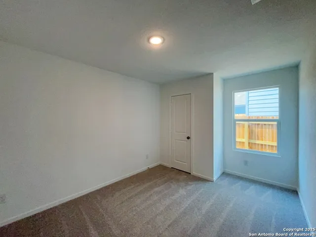 an empty room with a window and wooden floor