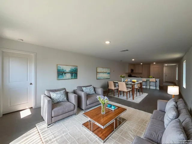 a living room with furniture and view of kitchen
