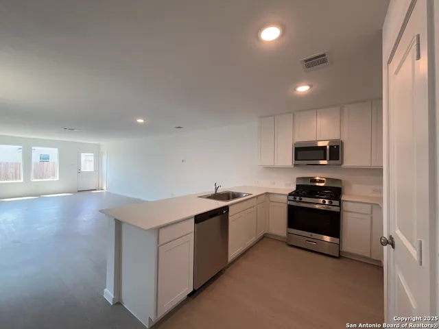 a kitchen with stainless steel appliances granite countertop a sink and a stove top oven