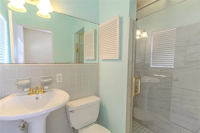 a bathroom with a sink toilet and shower