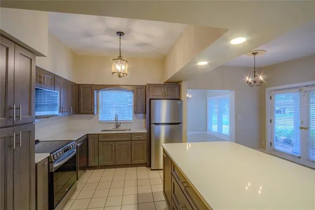 a kitchen that has a lot of cabinets and stainless steel appliances