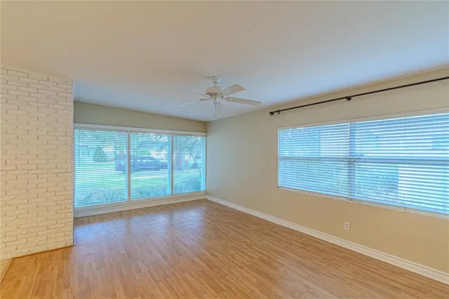 a view of a livingroom with wooden floor and a ceiling fan