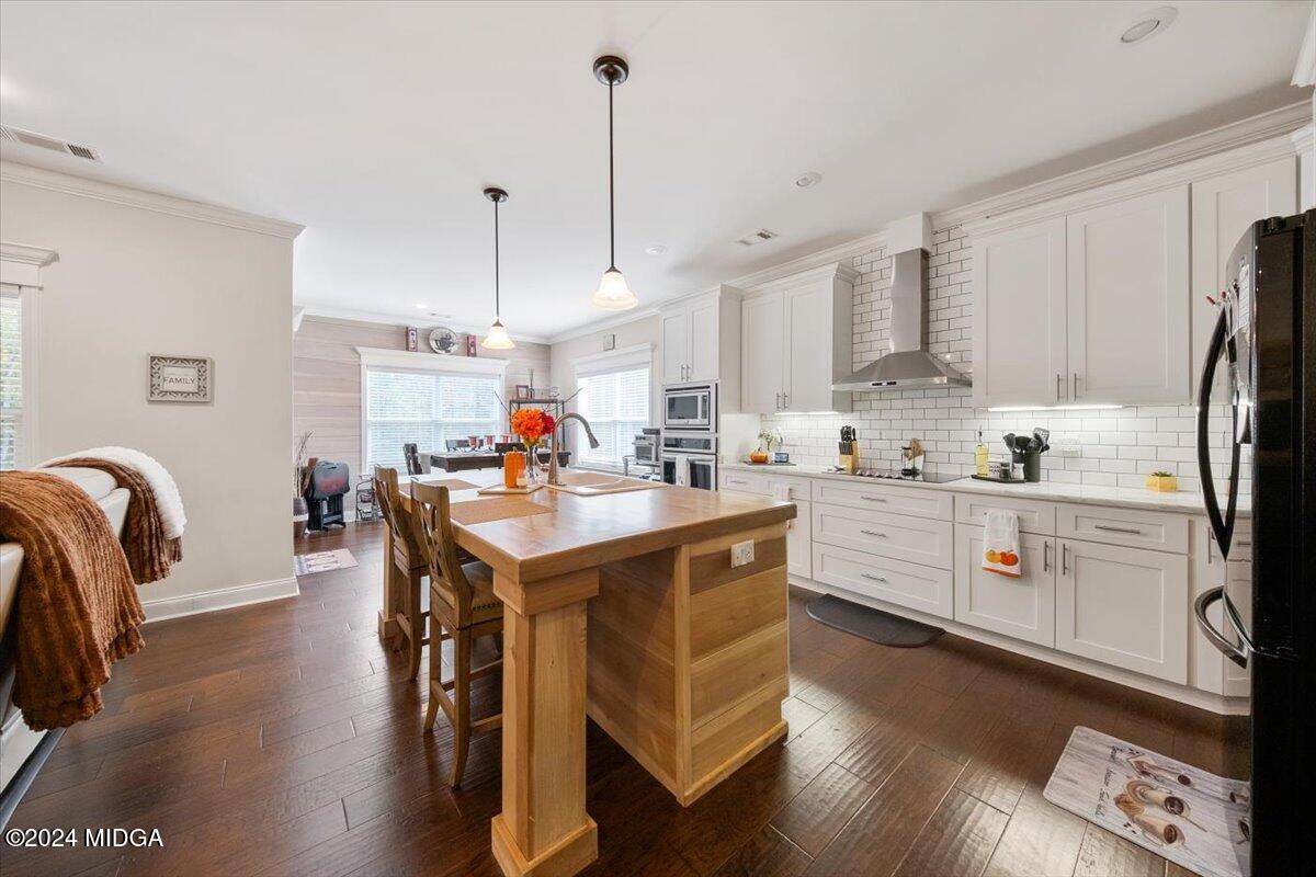 155 Carters Way Forsyth, GA 31029 - Photo 7 of 28 a kitchen with stainless steel appliances granite countertop a sink a stove a refrigerator a dining table and chairs with wooden floor