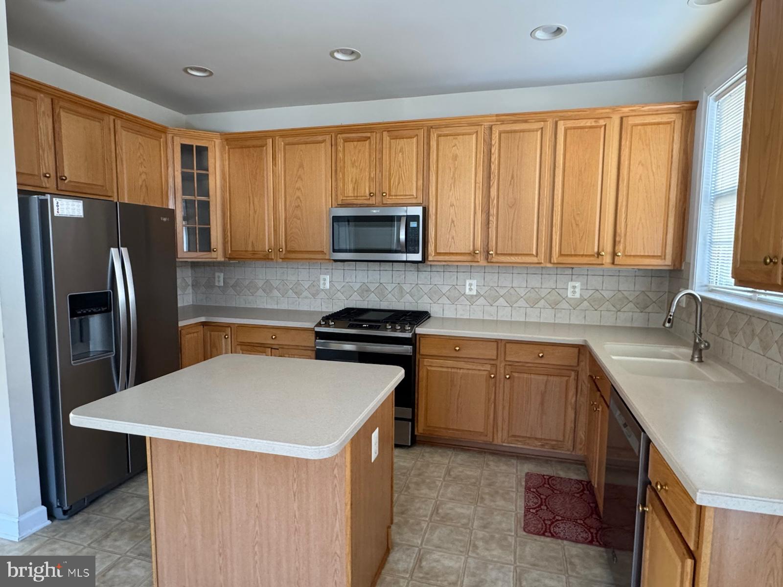 42474 Magellan Square Brambleton, VA 20148 - Photo 13 of 31 a kitchen with stainless steel appliances granite countertop a refrigerator stove microwave sink and cabinets