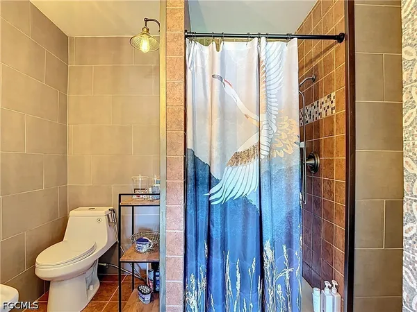 a bathroom with a sink a toilet a mirror and shower