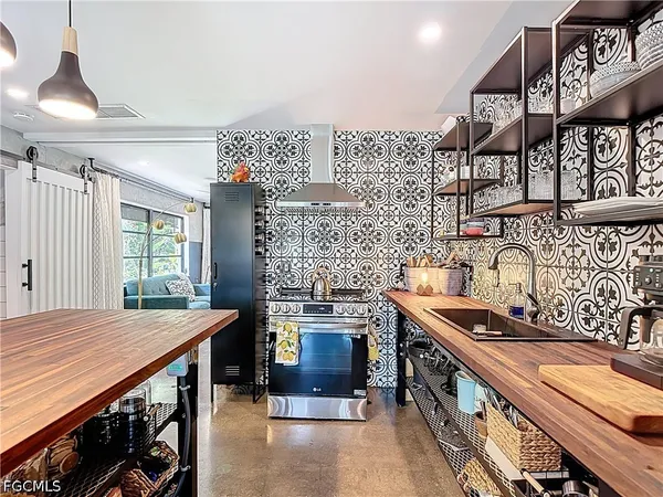a dining hall with stainless steel appliances kitchen island a stove and a table