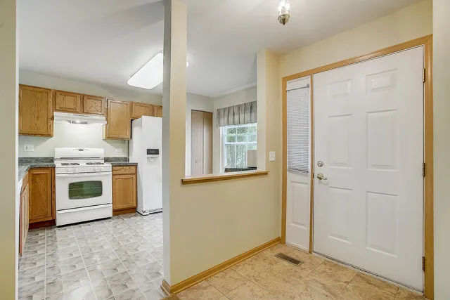 a view of kitchen with sink refrigerator and window