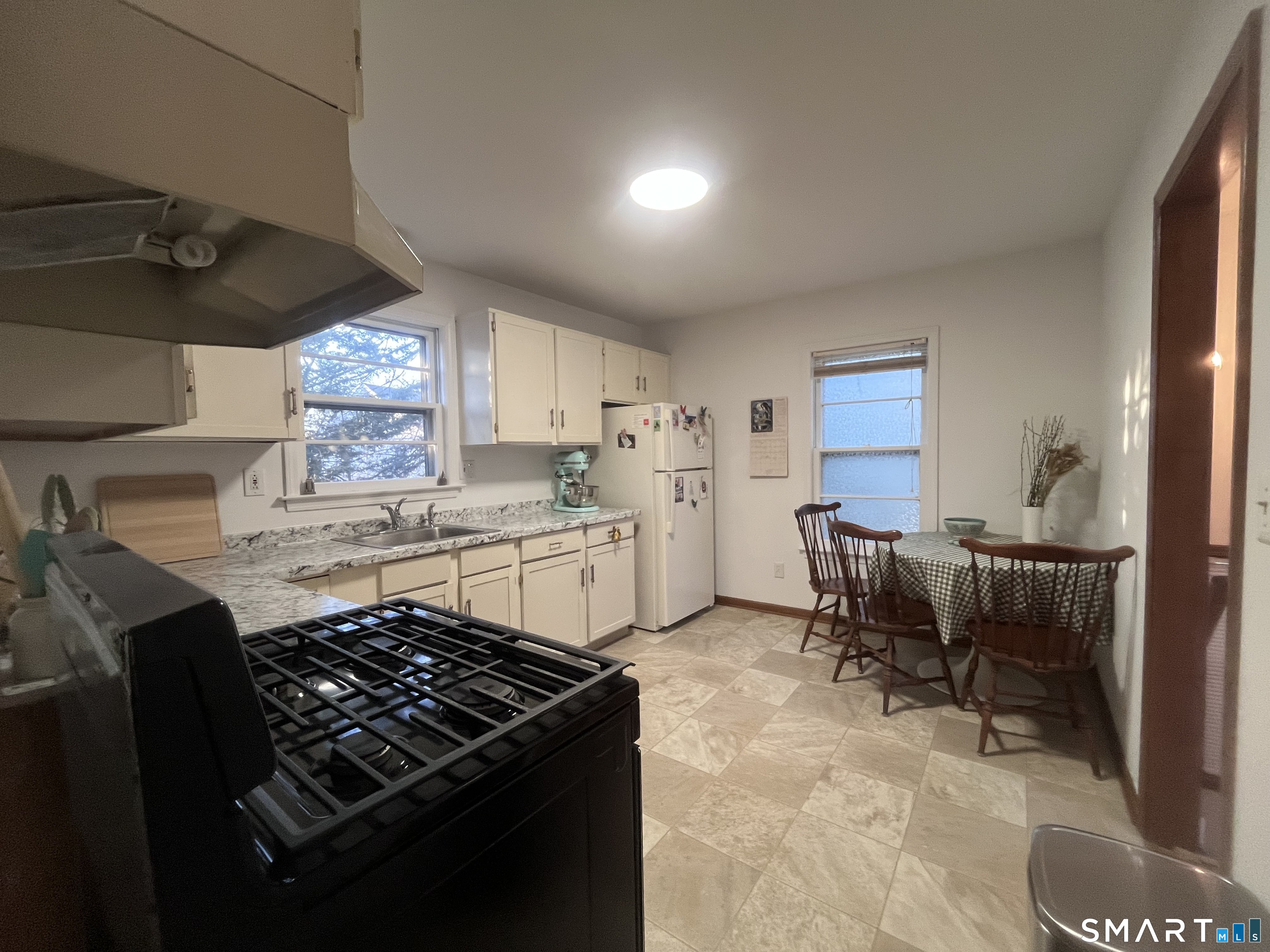 124 Thorpe Street Fairfield, CT 06824 - Photo 11 of 23 a kitchen with a table and chairs