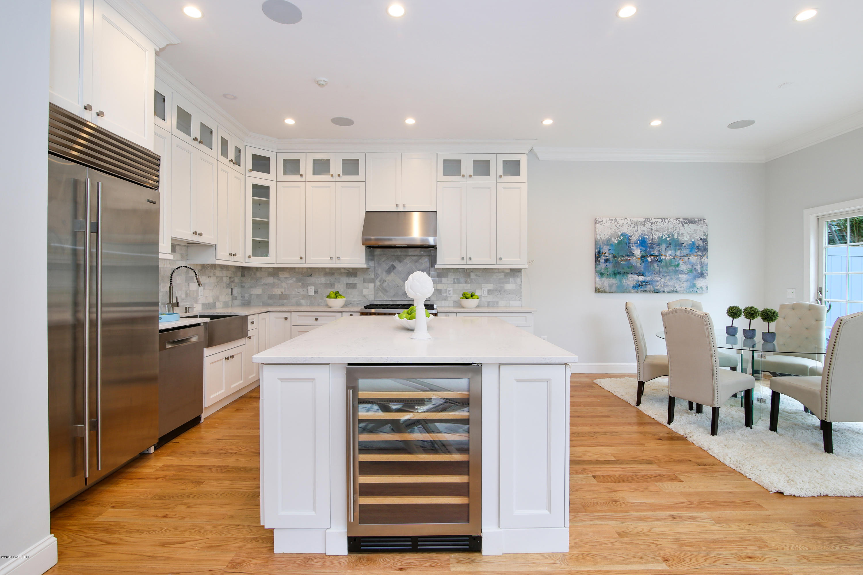 a kitchen with kitchen island wooden cabinets and refrigerator