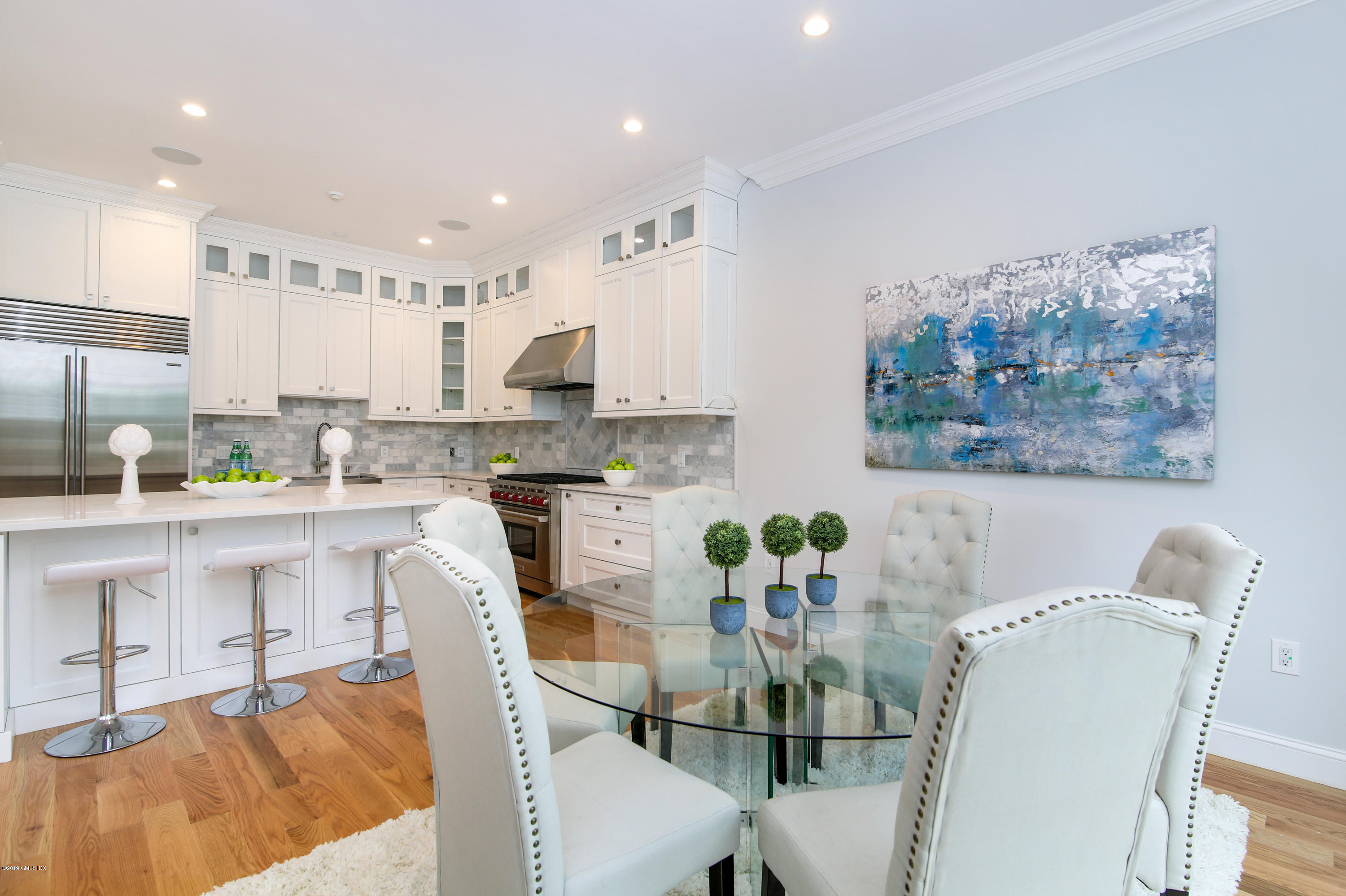 8 Sound Beach Ave Extension, Unit 4 Riverside, CT 06878 - Photo 6 of 25 a kitchen with stainless steel appliances granite countertop a white cabinets a stove top oven and a dining table with garden view