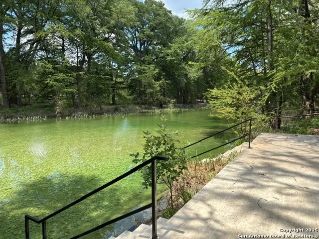 a view of a lake with a floor to ceiling window next to a yard