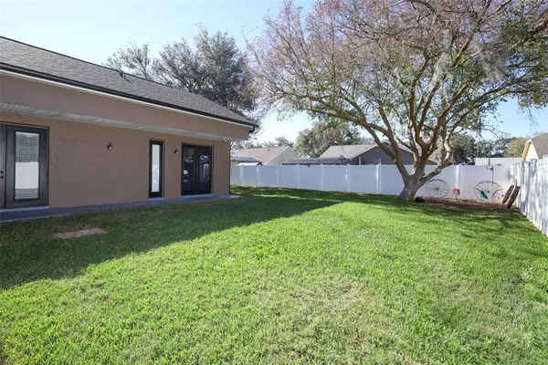 a view of a house with backyard and a tree