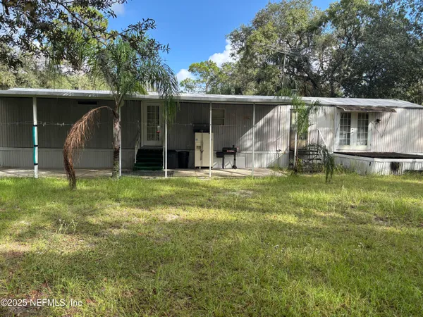 a view of a house with backyard and a tree