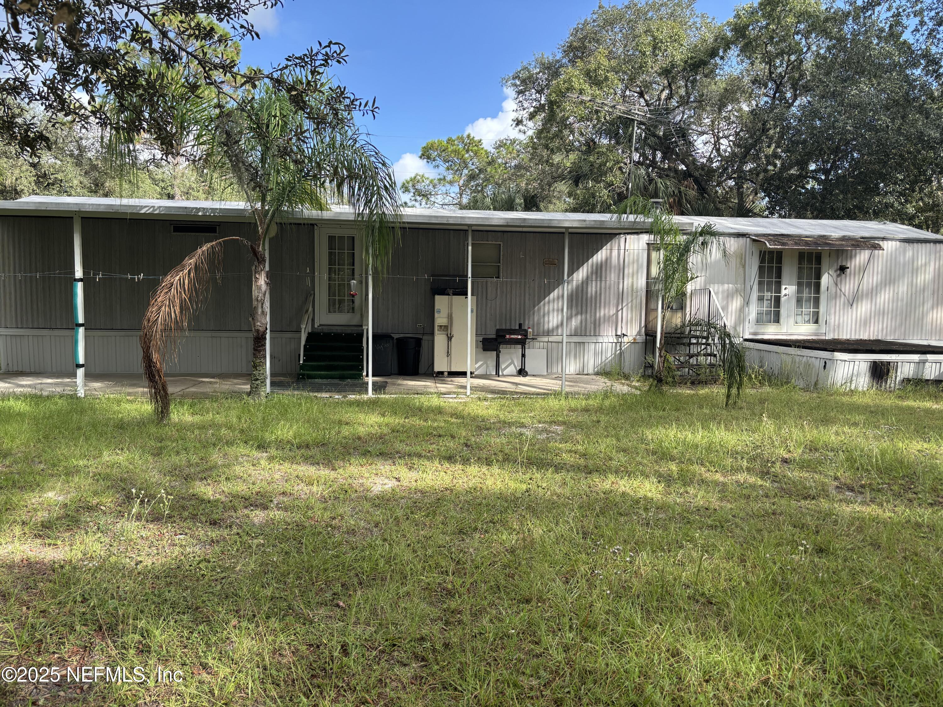 a view of a house with backyard and a tree