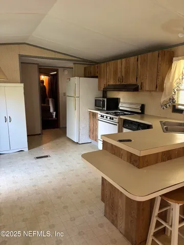 a kitchen with a stove a refrigerator and a sink