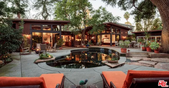 a view of a patio with table and chairs under an umbrella with a fire pit