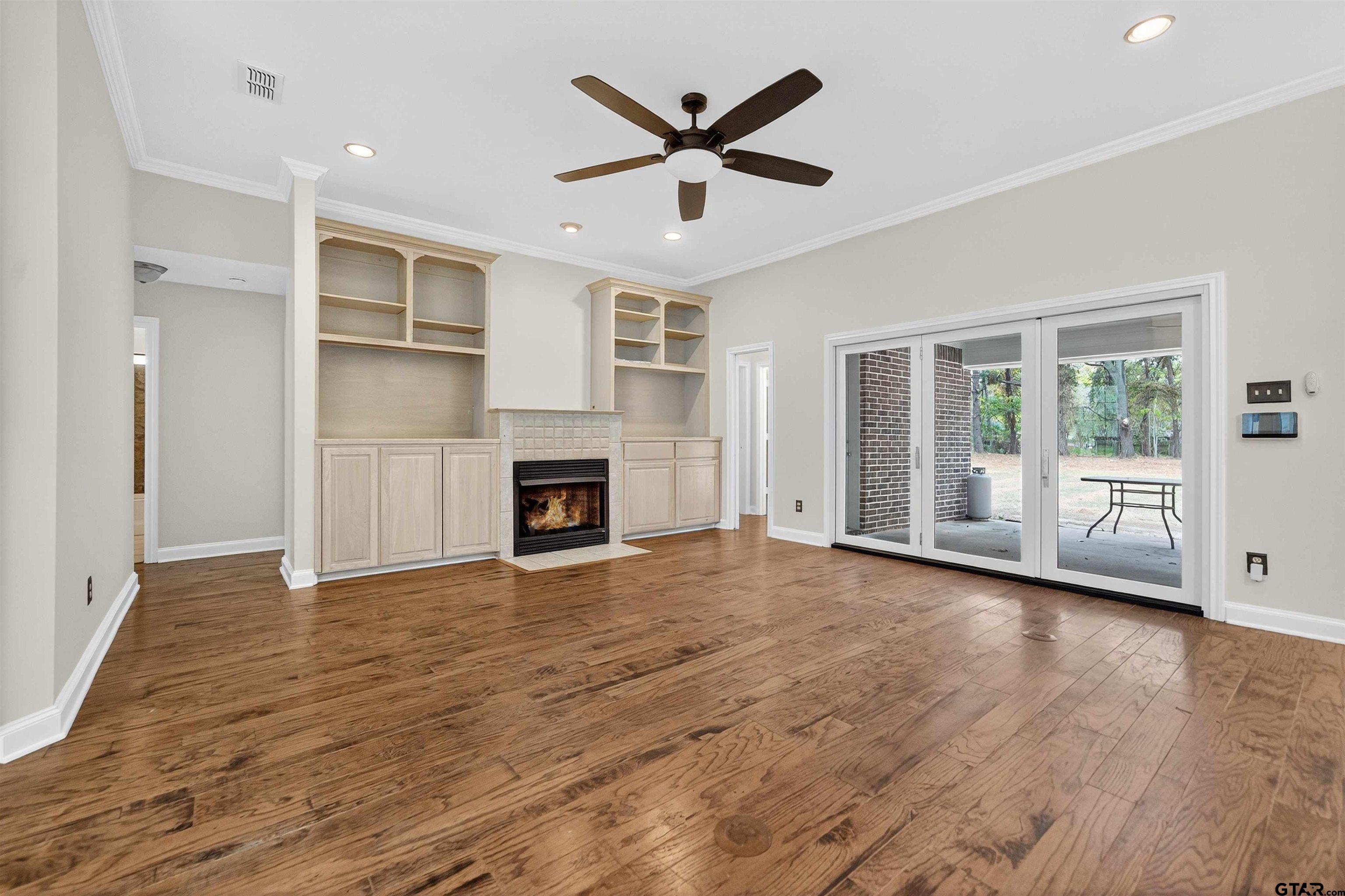 21112 Altuda Lane Flint, TX 75762 - Photo 17 of 48 an empty room with wooden floor a ceiling fan and windows