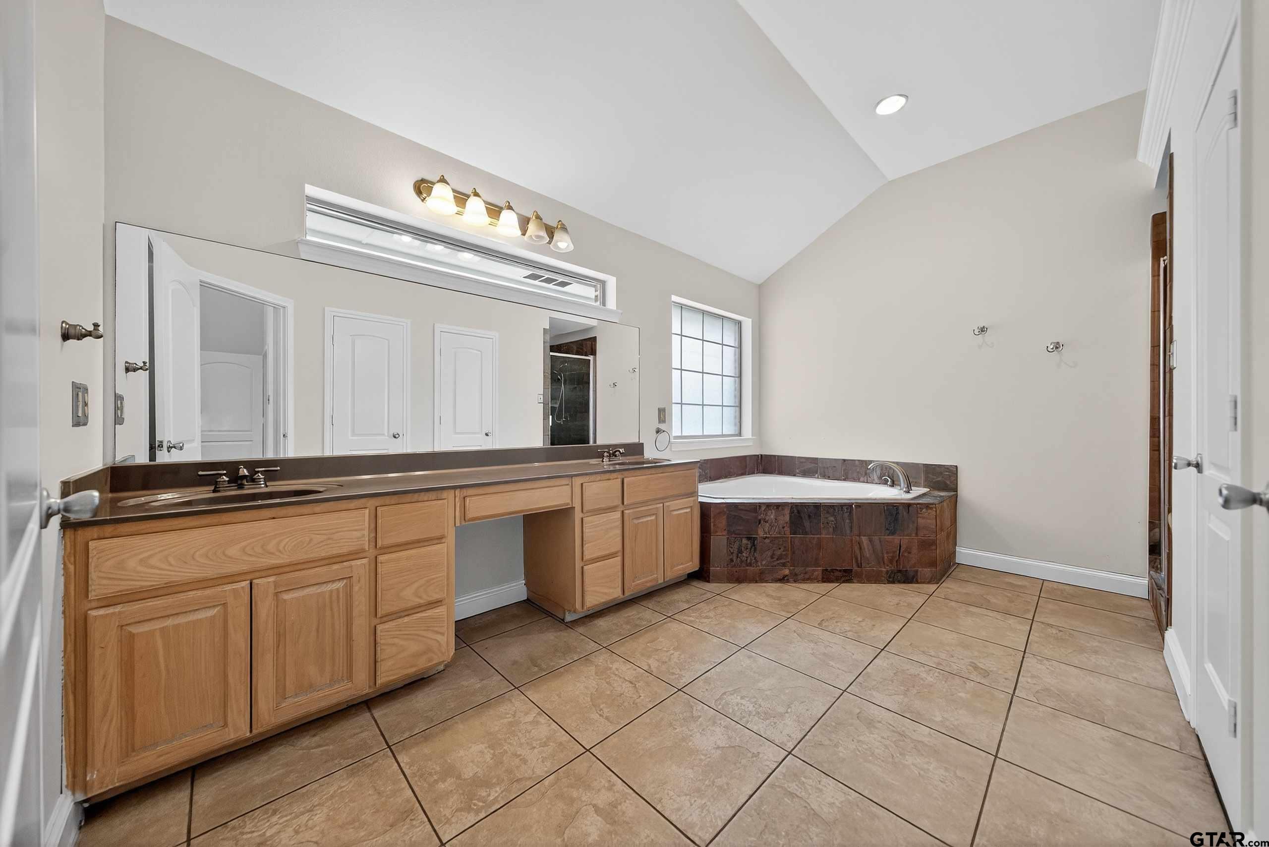 21112 Altuda Lane Flint, TX 75762 - Photo 24 of 48 a large bathroom with a double vanity sink a mirror and a bathtub