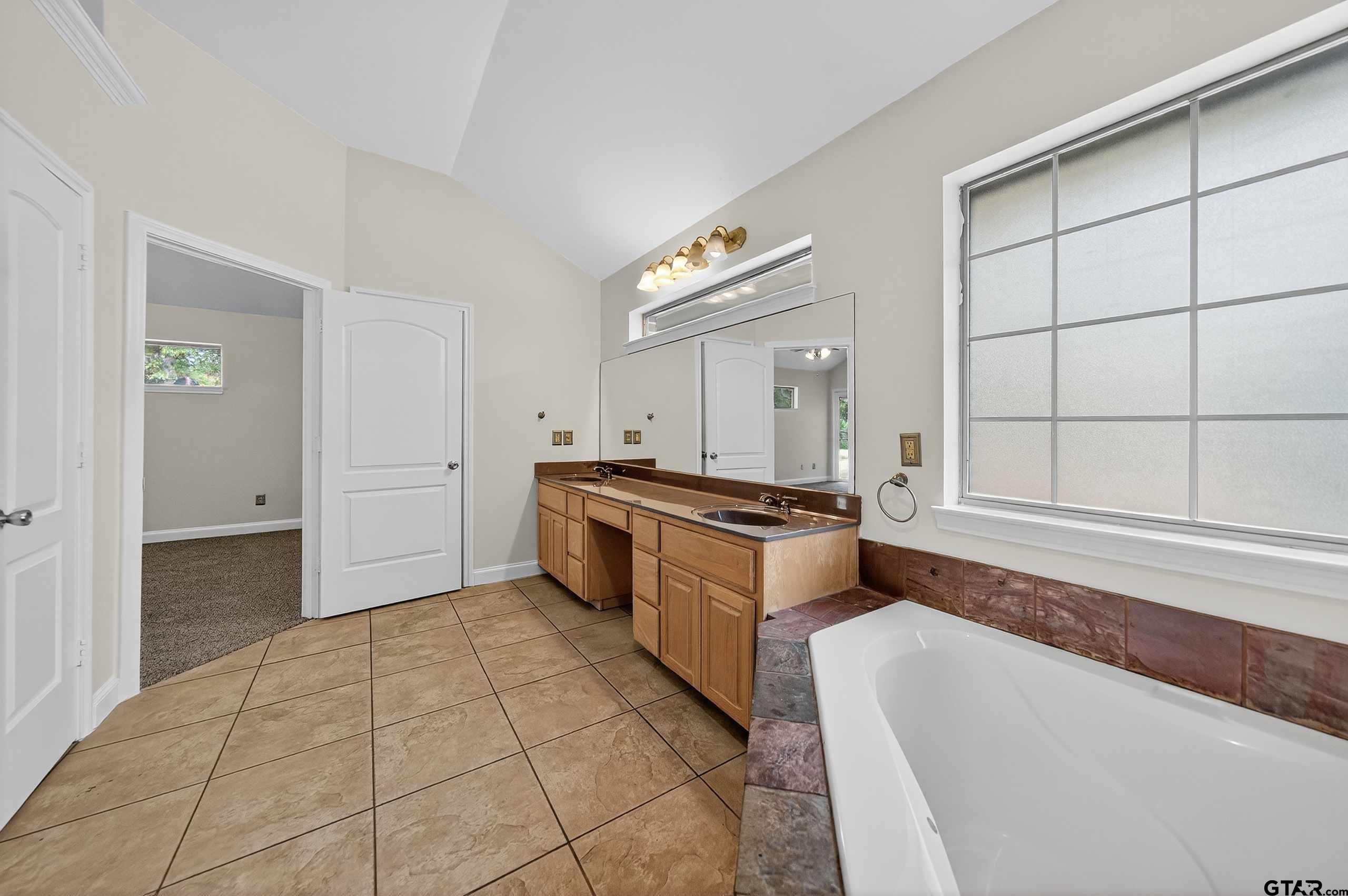21112 Altuda Lane Flint, TX 75762 - Photo 26 of 48 a large white bathroom with a granite countertop sink and a bathtub