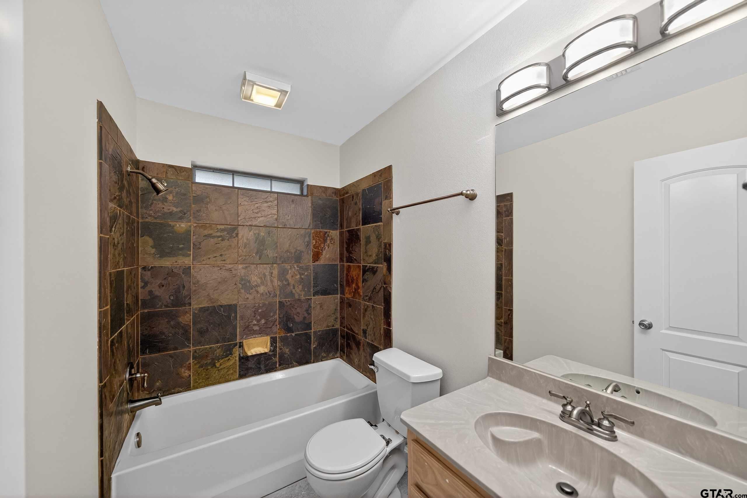 21112 Altuda Lane Flint, TX 75762 - Photo 35 of 48 a bathroom with a bathtub shower sink mirror vanity and toilet