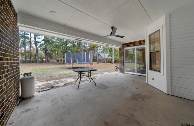a view of a porch with furniture and a backyard