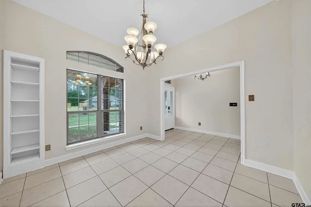 a view of an empty room with a chandelier