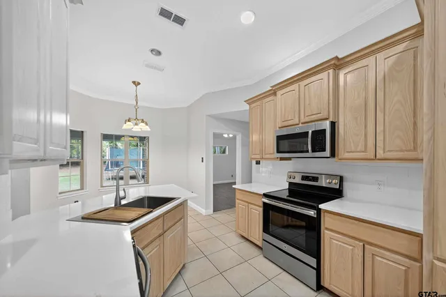 a kitchen with stainless steel appliances granite countertop a sink a stove and a refrigerator