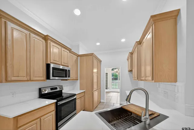 a kitchen with granite countertop a stove a sink and a microwave