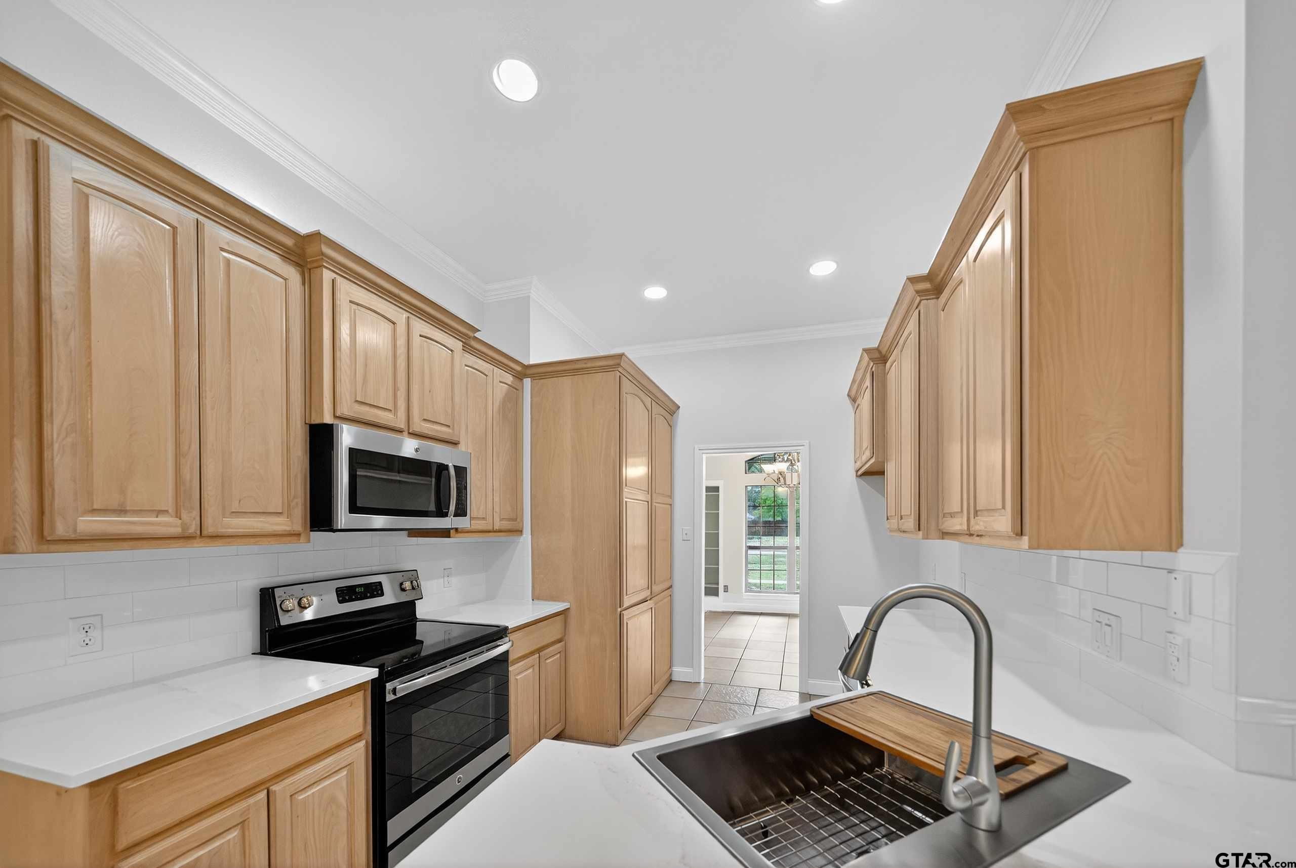 21112 Altuda Lane Flint, TX 75762 - Photo 10 of 48 a kitchen with granite countertop a stove a sink and a microwave
