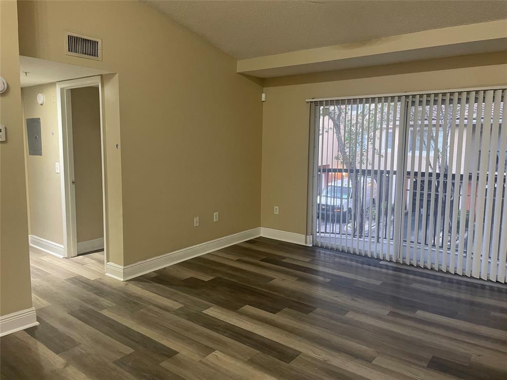 4179 Haverhill Road, Unit 602 West Palm Beach, FL 33417 - Photo 7 of 15 a view of an empty room with wooden floor and a window