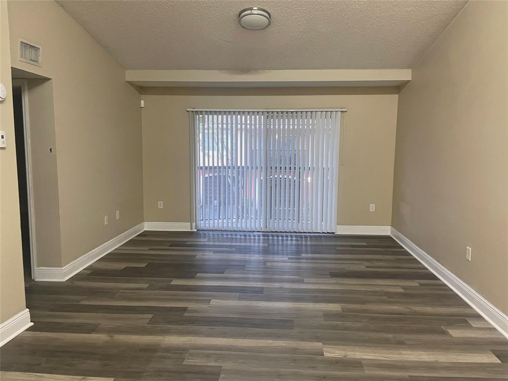 4179 Haverhill Road, Unit 602 West Palm Beach, FL 33417 - Photo 9 of 15 a view of an empty room with wooden floor and a window