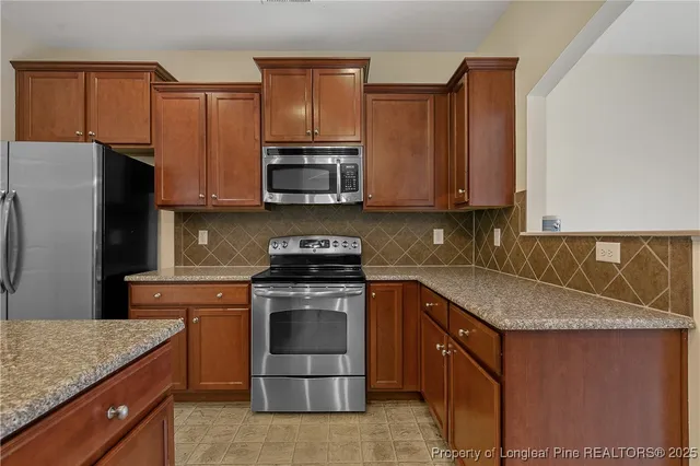 a view of an empty room with a chandelier fan