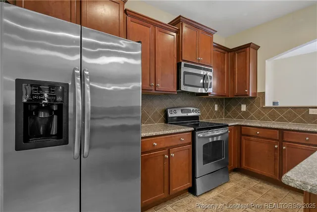 a kitchen with stainless steel appliances granite countertop cabinets and refrigerator