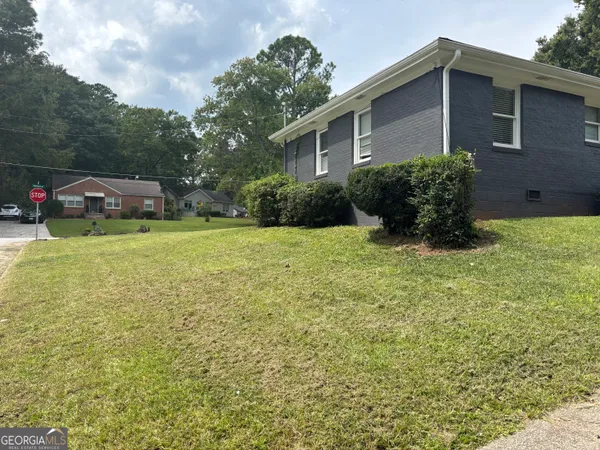 a view of a house with a yard and sitting area