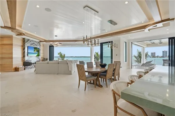 a living room with furniture a dining table and chairs with wooden floor